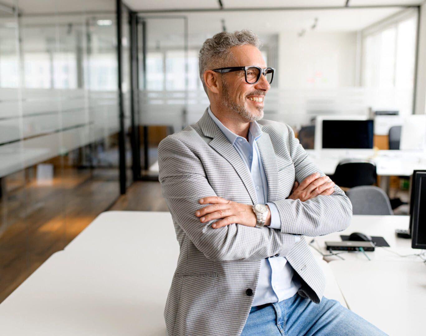 Man smiling in modern office setting.