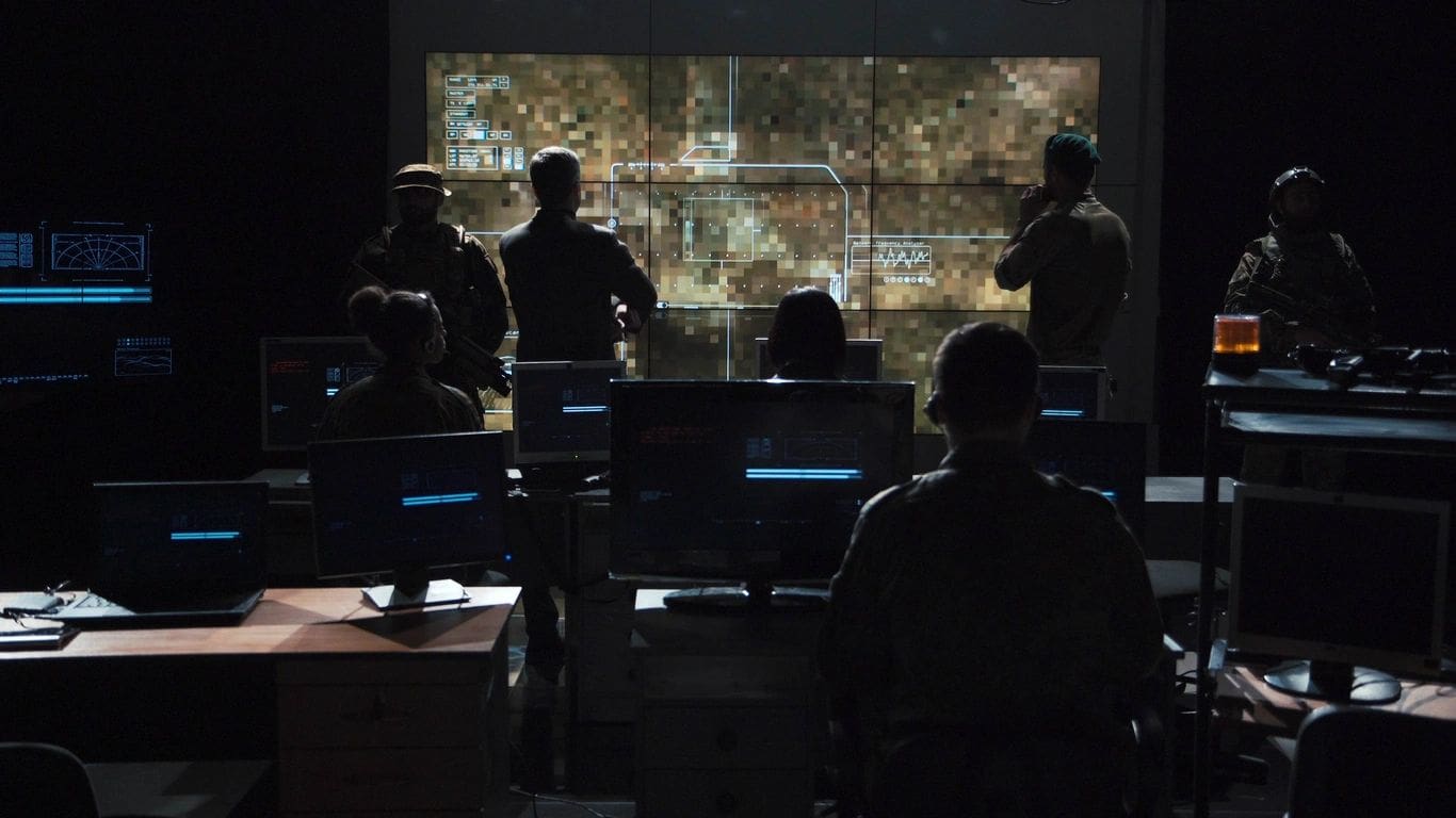 Military personnel analyzing data on large screens.
