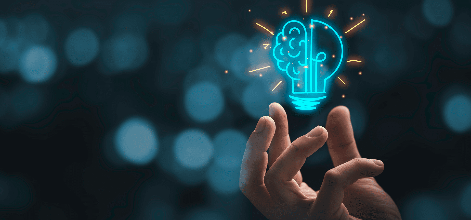 Hand holding a glowing light bulb with a brain circuit design symbolizing innovation.