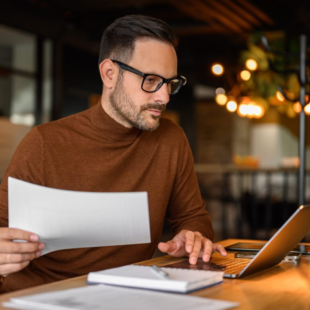 Man working at desk with laptop.